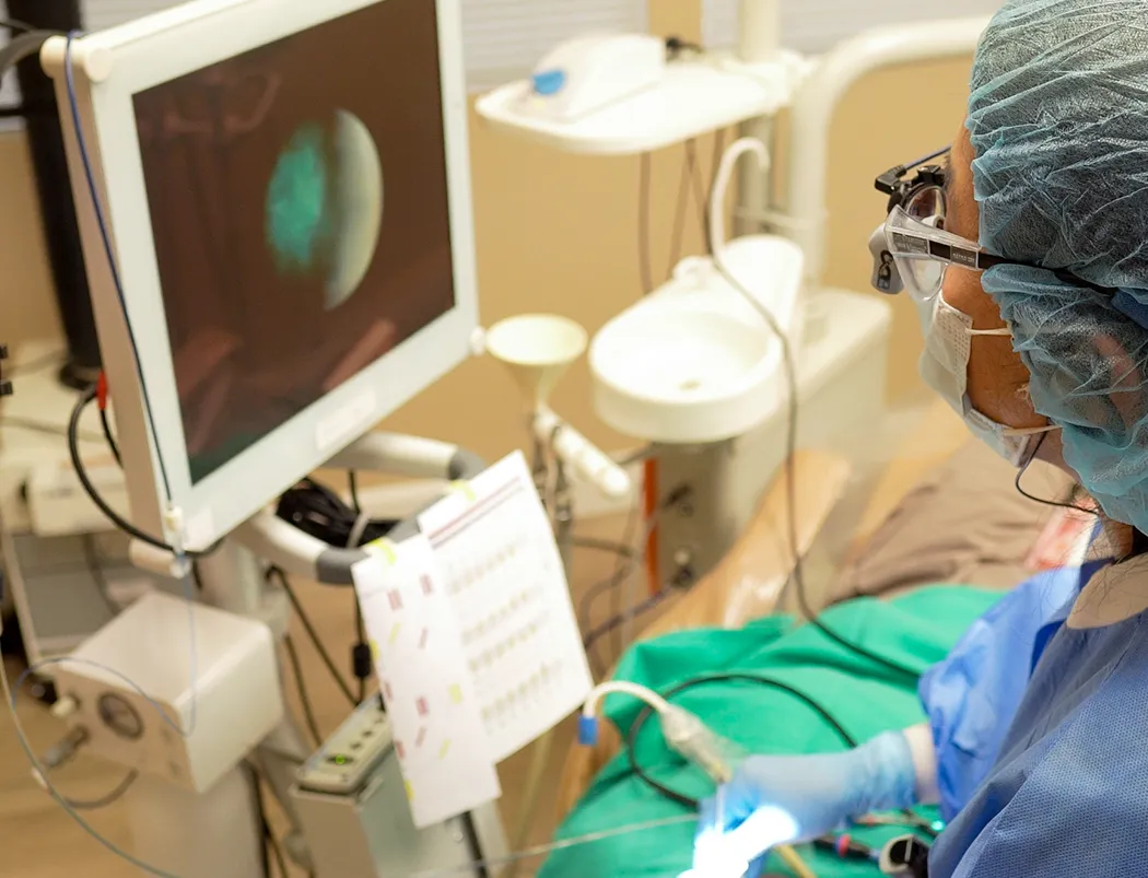 A periodontist using an endoscopic perioscope with a monitor during treatment