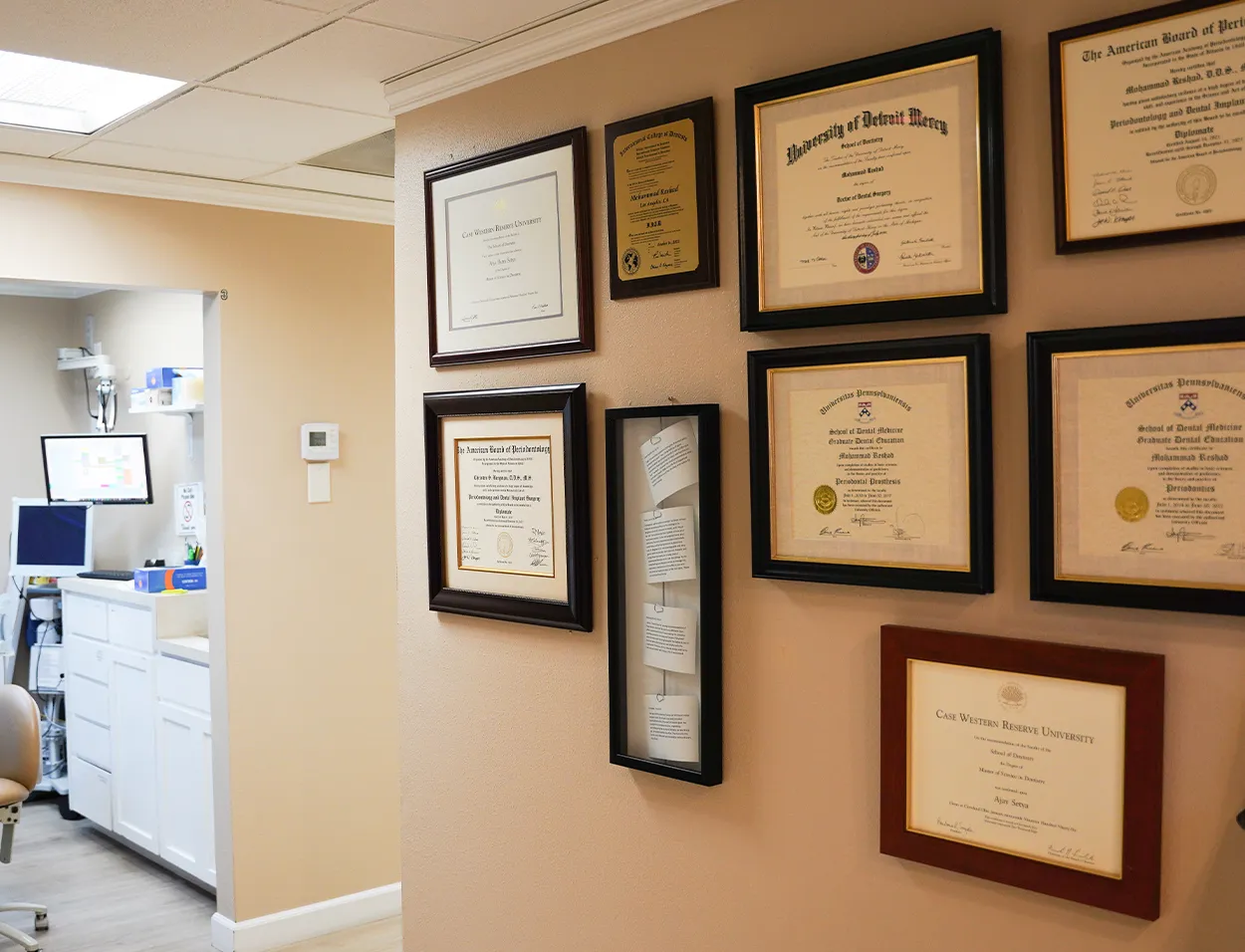 Framed diplomas and certifications on the wall of the Mission Viejo office